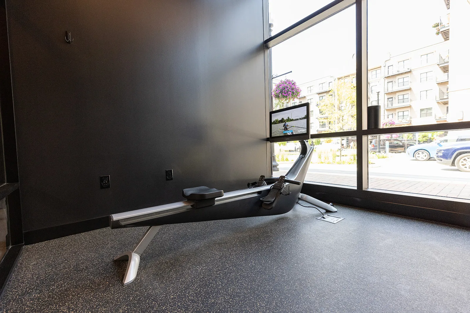 A HYDROW connected rower beside the storefront windows